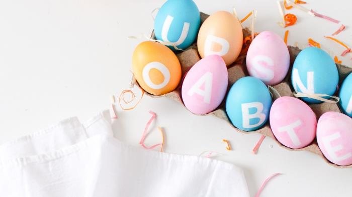 beyaz harflerle süslemeli pastel tonlarda renkli yumurta modelleri, kolay ve modern paskalya dekorasyonu
