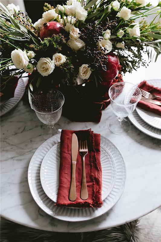 beyaz tabaklarda kırmızı bez peçete, narlı beyaz gül buketinde merkez, estetik Noel masa dekorasyonu
