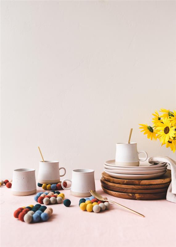 seramik kupalar ve ahşap tabaklar, ev yapımı yılbaşı hediyeleri, renkli ponponlardan yapılmış bardak altlıkları