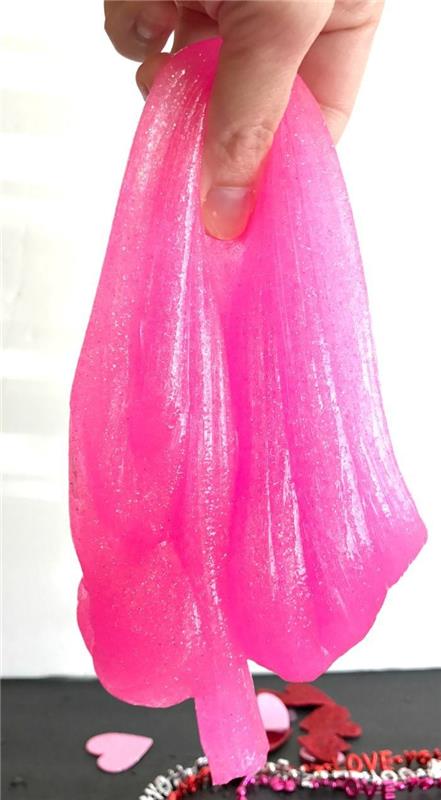 Ingredienti slime di colore rosa e molto elastico, pasta modellabile tenuta sospesa in mano