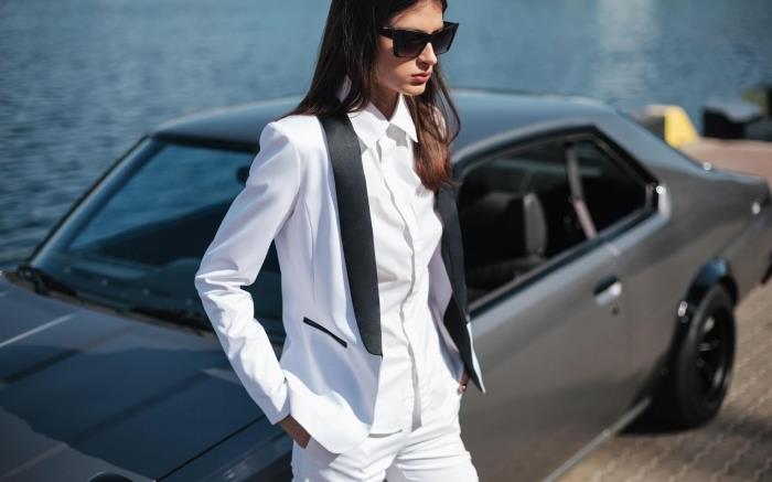 moters kelnių kostiumo modelis ceremonijai, elegantiška moters išvaizda ir stilius baltame kostiume su juoda apykakle