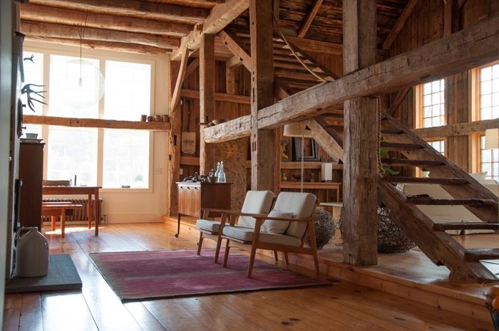 dönüştürülmüş bir asma ahırda dönüştürülebilir çatı katı fikri, ahşap duvarlı oturma odası dekorasyonu ve ahşap mobilyalı zemin