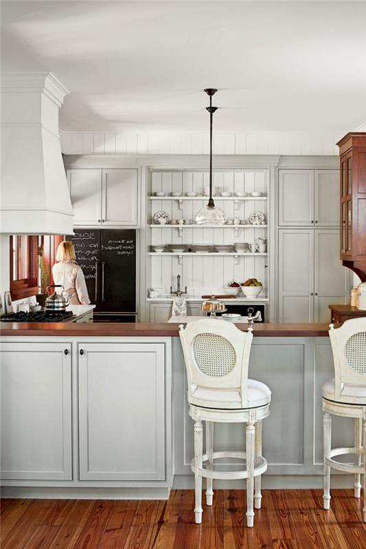 virtuvė su balto medžio dailylentėmis, baltos retro kėdės, lakuotos medinės virtuvės grindys, juoda atmintinė, lentynos