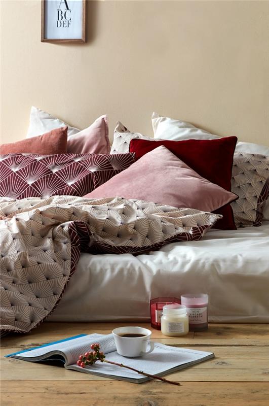 minkštų spalvų antklodžių užvalkalai, lovos užtiesalo geometriniai raštai, aromatinės žvakės, medinės grindys