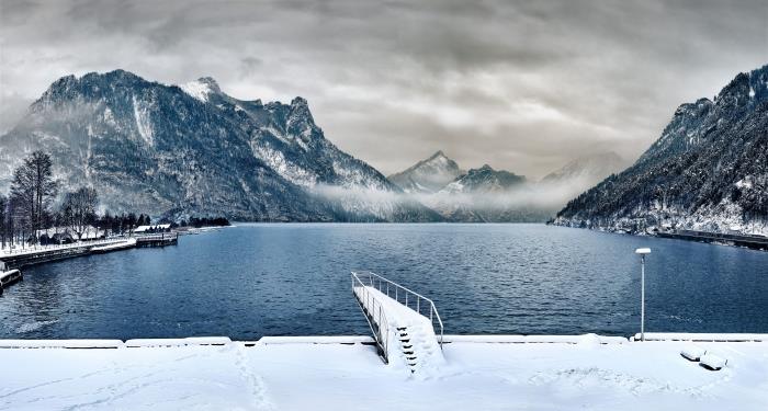 kompiuterio tapetai su žiemos gamtos nuotrauka su pilku dangumi, ežero ir snieguotų kalnų su rūku nuotrauka