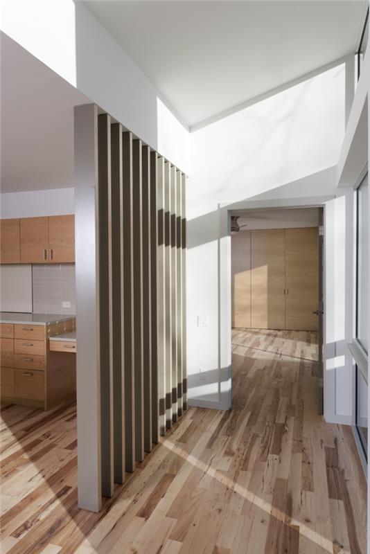 modernus interjero dizainas atviroje virtuvėje su baltomis sienomis su medinėmis grindimis ir baldais