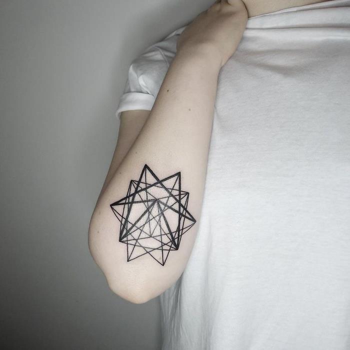 geometrijska tetovaža, geometrijska zvezda, pod komolcem, obleka osebe v beli srajci, stoji pred belim ozadjem