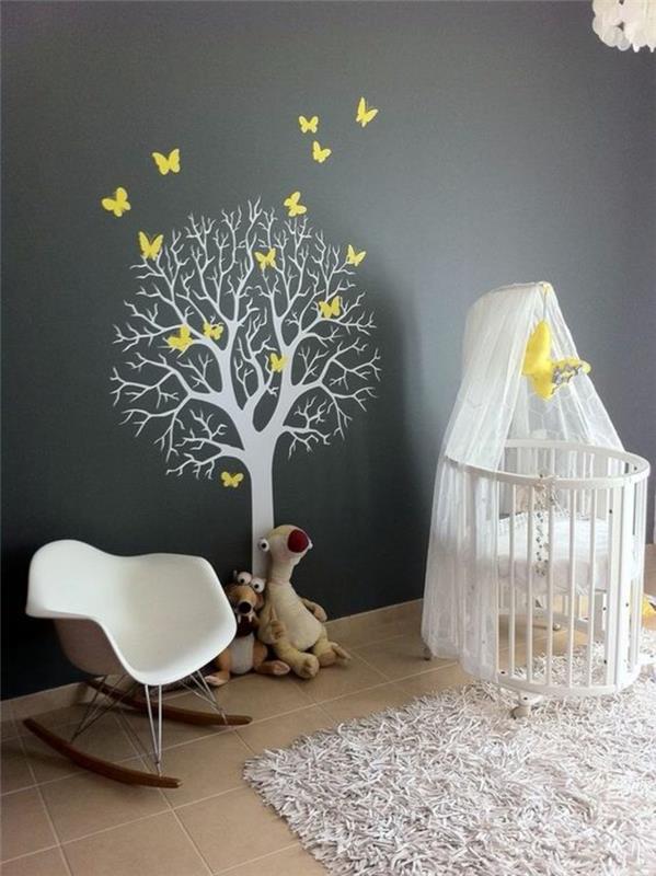 Beyaz renkli yuvarlak yatak ve beyaz renkli ağaç ve ördek mavisi duvarda sarı kelebekler olan kız bebek odası çıkartmaları