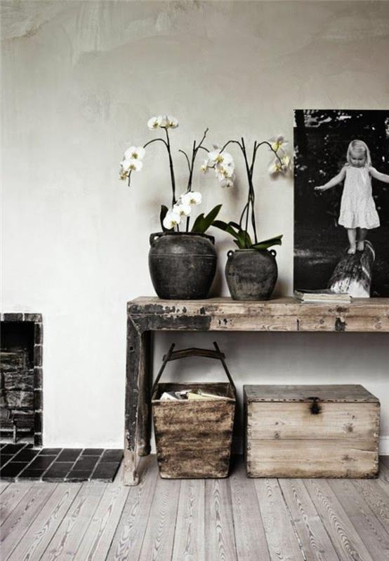 Tavolo di legno rustico con due vasi e orchidee, decorazione con una foto grande bianco e nero di una bimba