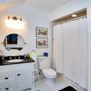 Interni in bianco e nero di un piccolo bagno, dove il tono principale è il bianco