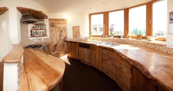 kmečko notranje oblikovanje v kuhinji z belimi stenami s pohištvom iz surovega lesa in bež mozaičnimi ploščicami