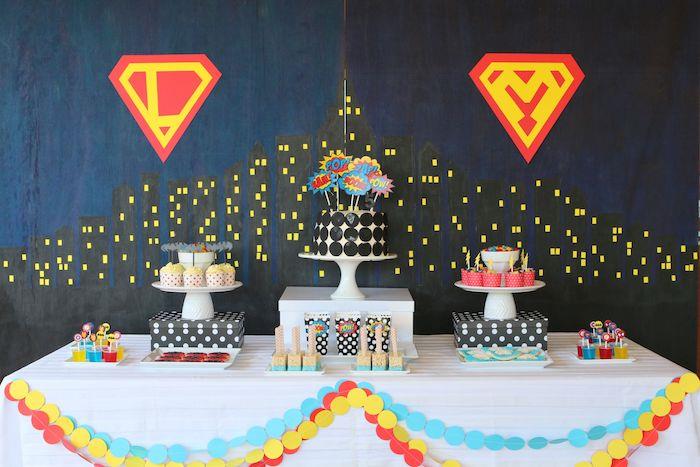 superherojų vakarėlio užmaskavimo tema su juodu ir tamsiai mėlynu fonu, saldainių baras su keksiukais ir originaliu pyragu