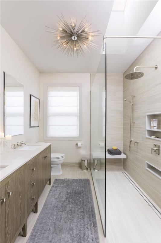 trendovska postavitev kopalnice po dolžini s svetlimi stenami in spuščenim stropom, ki pokriva plošče za prenovo kopalnice
