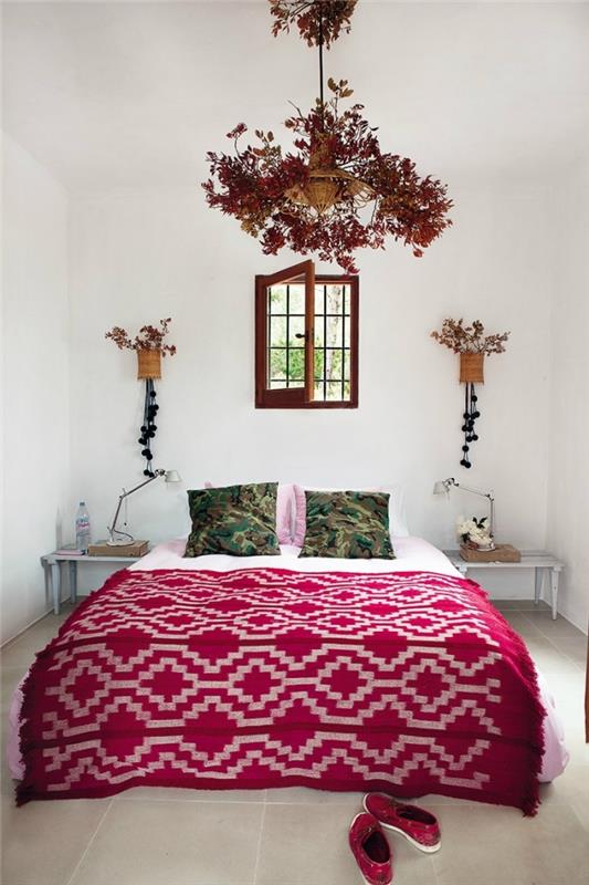 primer boemske spalnice z belimi stenami z majhnim karirastim oknom in cvetličnimi visečimi lučmi z vazo iz rastlinskih vlaken