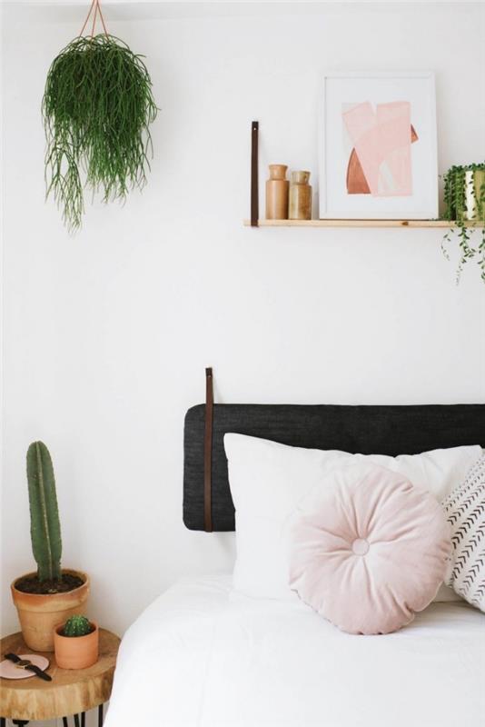 beyaz bir yatak odasında minderli bir başlık, yeşil bitkiler ve bakır metal objeler ile jungalov dekoru nasıl yapılır