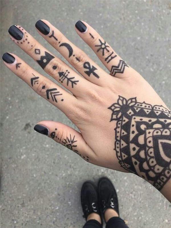 chna rankos tatuiruotė, sudaryta iš mandalos dizaino ant riešo ir geometrinių genčių raštų, tatuiruotų ant pirštų