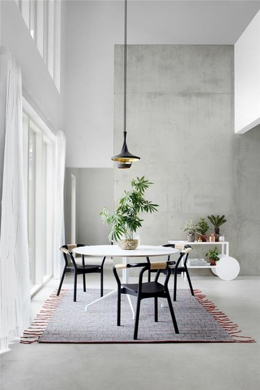 pigus-valgomasis stalas-baltas stalas-spalvingas-kilimas-žalias-augalas-interjeras-siena pilkame betone