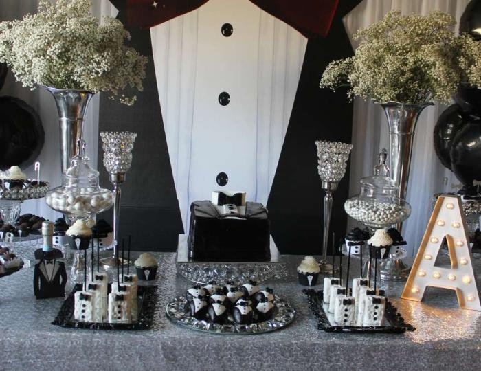 30 metų vyro gimtadienio stalo pavyzdys, papuoštas balta ir juoda spalva su sidabriniais indais, stilinga vyrų vakarėlio puošmena
