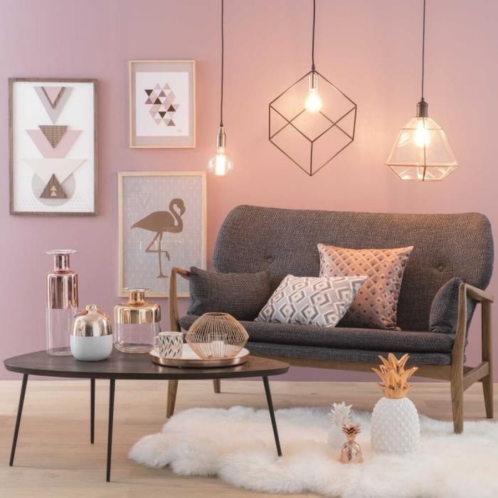 dekoratyviniai sidabro dekoro objektai, moderni svetainė šviesiai rožinėmis sienomis su pramoninio stiliaus pakabinama šviesa ir mediniais nuotraukų rėmeliais