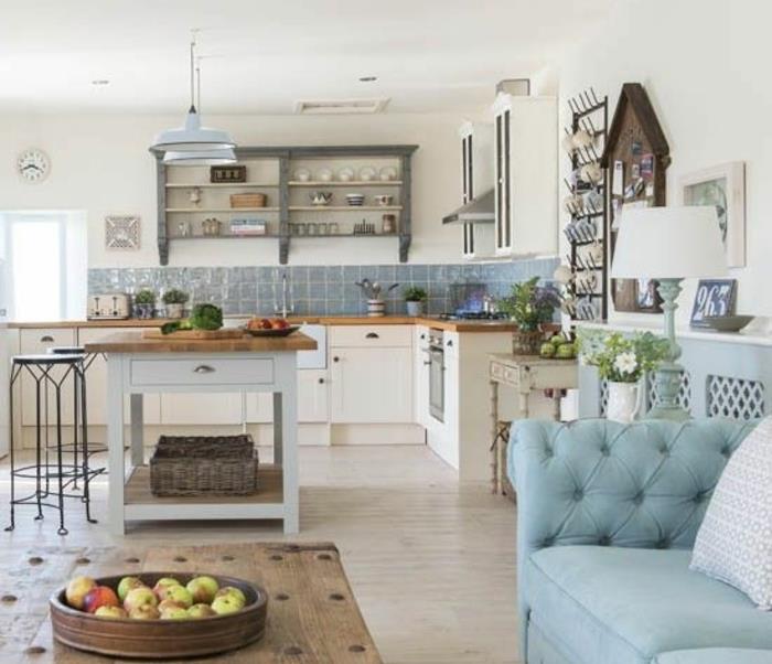 elegantna podeželska kuhinja, modre ploščice, lesena mizica, modri kavč, bela kuhinjska sprednja stran, polica za shranjevanje posode, lesen osrednji otok