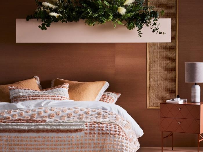 pembe ve pişmiş toprak vurgulu modern bir yetişkin yatak odası dekorunun nasıl yapılacağına örnek, bej ve kahverengi tonlarında ponpon süslemeli yatak örtüsü fikri