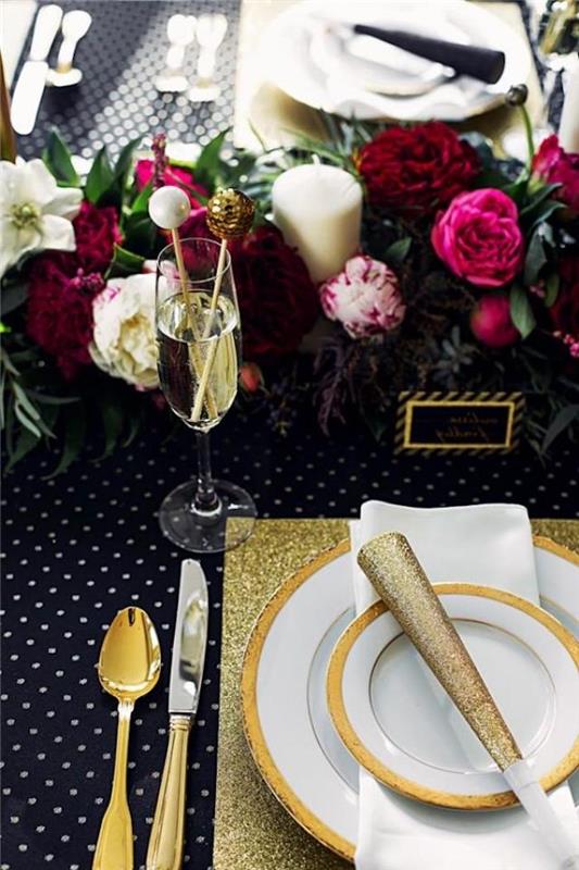 novoletna miza z okrasjem cvetja in tematiko v črno -zlati mizi za novo leto