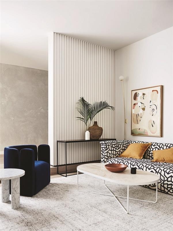 Beton efektli duvar bölümü ve modaya uygun kadife mobilyalar ile beyaz duvarlar ile modern salon dekorasyonu örneği