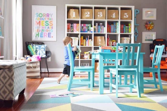 masa ve sandalyeler rafa hazır geometrik halıdaki oyuncaklarla güzel renkler dekor fikri oyun odası saklama dolabı oyuncak sadelik