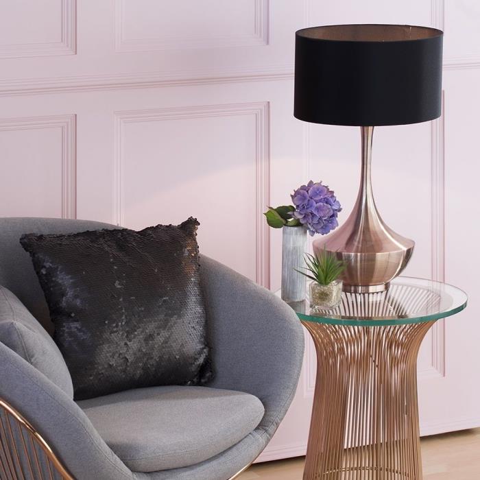 kokią spalvą susieti su pilka, svetainės dekoru su šviesiai rožinėmis sienomis su stiklo ir vario stalu, pilku foteliu su juodu dangteliu