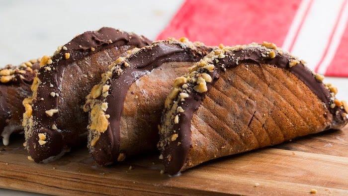 ideja sladkih predjedi, sladkih in zamrznjenih tacos, prelivenih s čokolado in oreščki