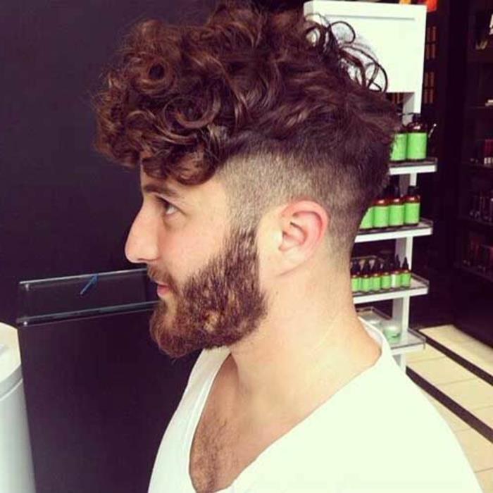 Acconciature capelli corti ricci di un uomo rasato ai lati della testa