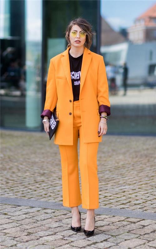 mandarinsko oranžna ženska hlačna obleka z moškim krojem, strukturirana jakna v kombinaciji z grafično majico za samozavesten videz