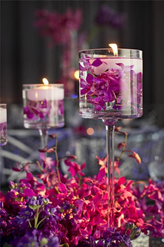visoke steklene vaze, napolnjene z vodo, cvetnimi listi in svečami, spomladanskimi cvetličnimi aranžmaji, rožnatimi in vijoličnimi cvetovi