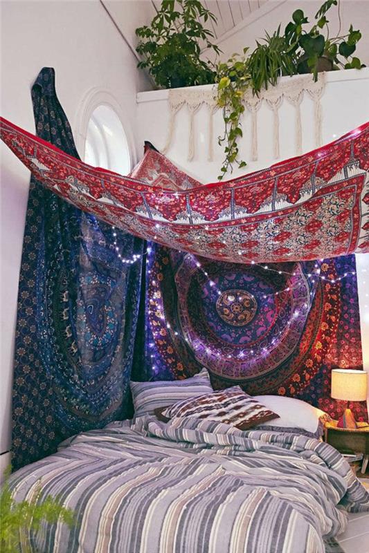 bohemiškas miegamojo dekoras, žali augalai, naktinė lempa, indiški kilimai
