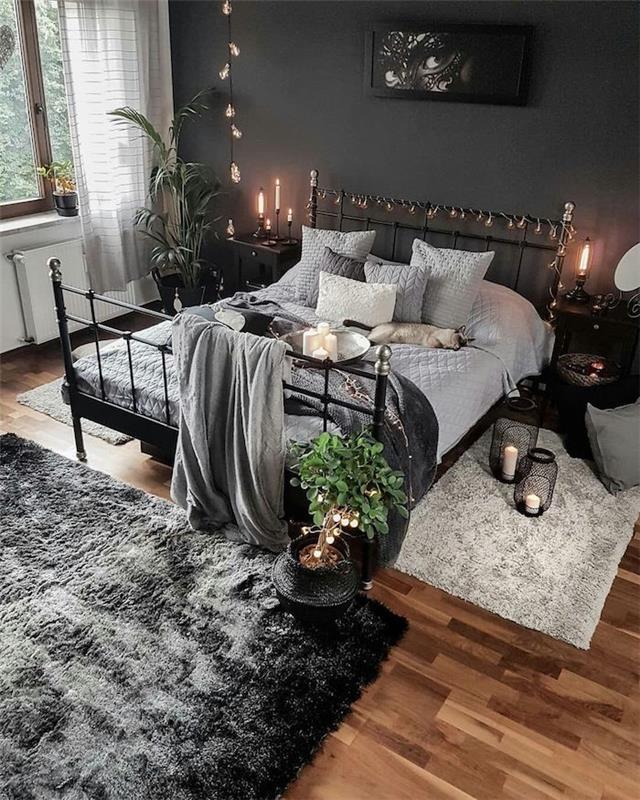Železna postelja, siva stena in bela pisalna miza, lanena in siva preproga, ki združuje ves dekor, lahki venci