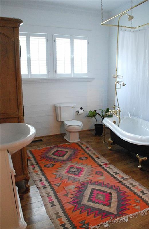 raudonas vonios kambario kilimas-tamsiai parketo grindys vonioje su vonia