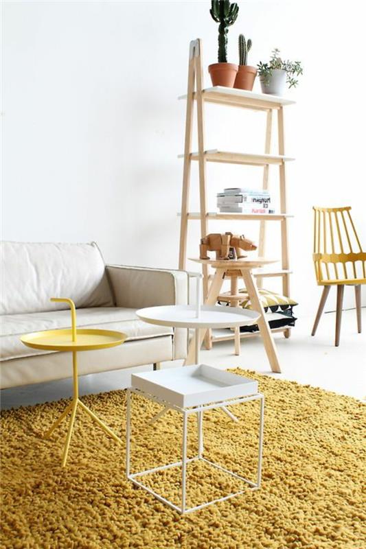 Doğal ahşap desenli İskandinav beyazı ve sarı hardal rengi oturma odası, rahat, canlı renkli kilim
