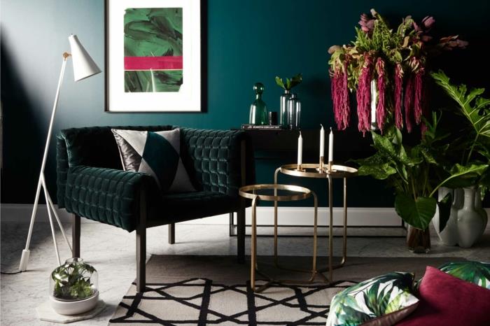 notranja dekoracija dnevne sobe v trendovskih barvah, račja modra stena, bela preproga s črnimi vzorci, zelene rastline, umetniško slikarstvo, majhne gnezdilne mize