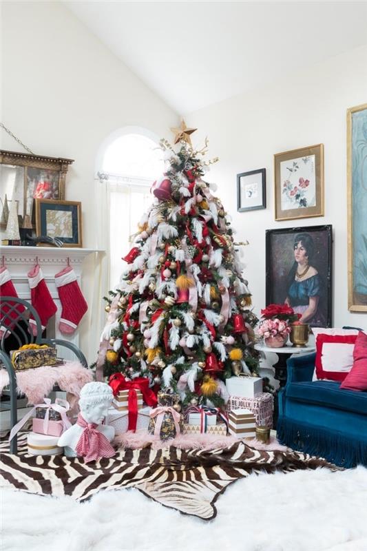 Kadife mobilyalarla retro tarzda döşenmiş katedral tavanlı beyaz oturma odası ve pembe kırmızı ve altınla dekore edilmiş Noel ağacı tasarımı