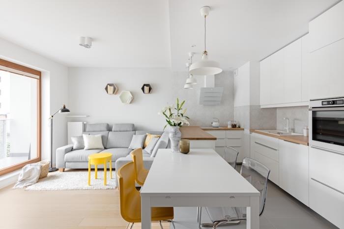 zamisel, kako urediti odprto kuhinjo v studiu v minimalističnem slogu z belimi stenami in pohištvom iz svetlega lesa