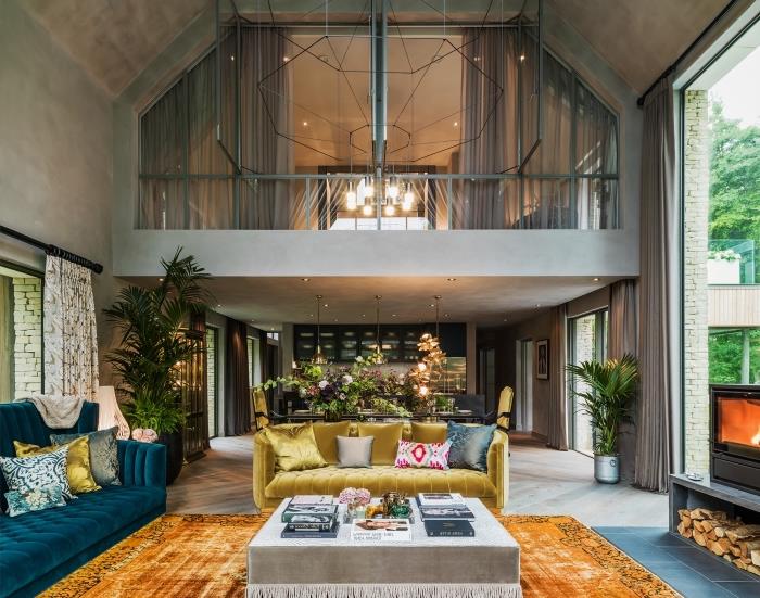 beton duvarlar ve gri ahşap zeminler ile bir asma çatı katında modern tarzda iç tasarım, kadife mobilyalı eklektik oturma odası dekoru