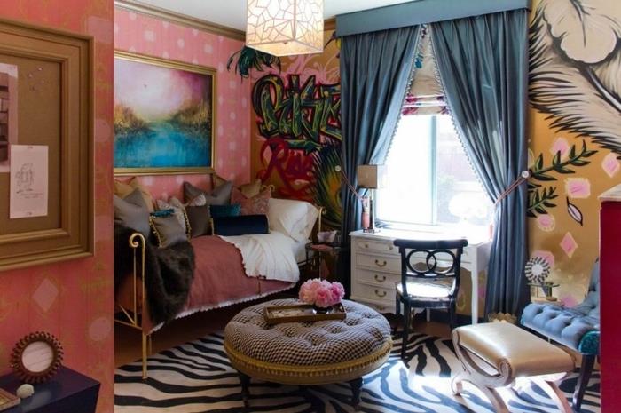 okrogla miza za puf, preproga iz imitacije zebre, modre zavese, roza stene, boemska postelja