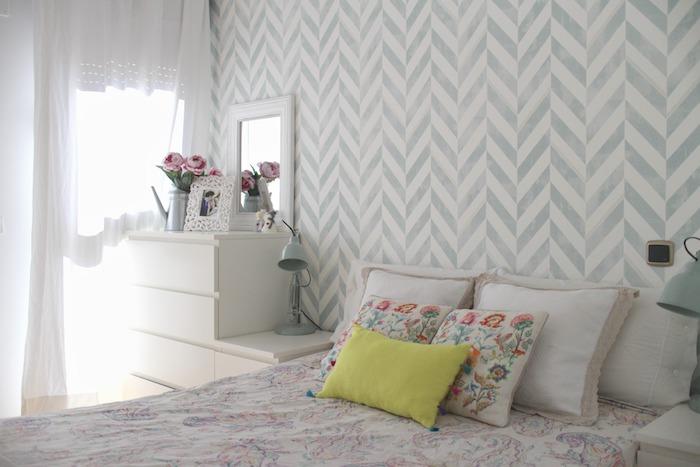 gri ve beyaz duvar halısı, renkli nevresim ve minderler, beyaz şifonyer, çiçek buketi, yetişkin yatak odası dekoru