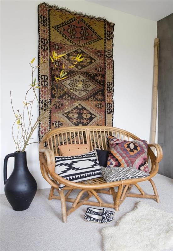 etninės apdailos idėja su austais baldais ir įvairiaspalvėmis dekoratyvinėmis pagalvėlėmis, rotango svetainės dizainas su etniniu gobelenu