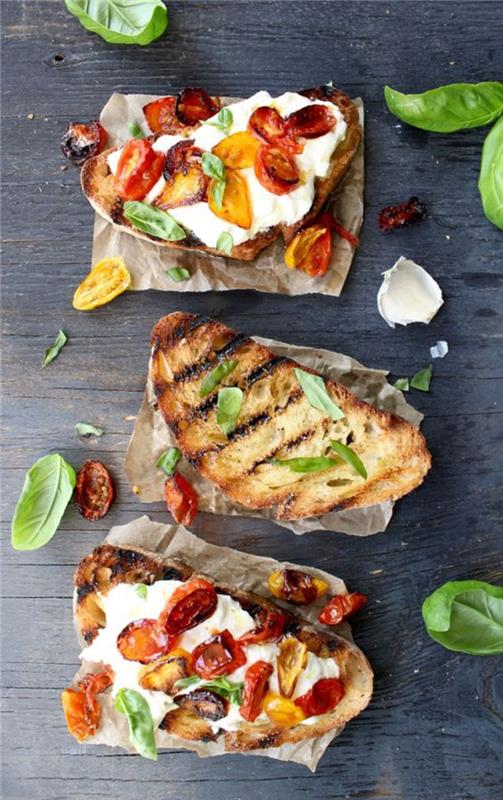 Buratta, pişmiş kiraz domates ve fesleğen ile kızarmış İtalyan ekmeği çıtır bruschetta