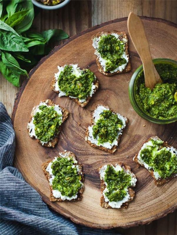 skrudinta duona su rupia duona su grietinėlės sūriu ir pesto, patiekiama ant kaimiško medinio rąsto, šalto užkandžio idėja