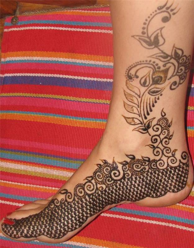 chna tatuiruotė, etninė pagalvėlė ir moters pėda su chna piešiniais