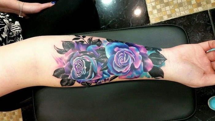 tetovaža pisanih vrtnic, črni lističi, ženska tetovaža na podlakti, dve vrtnici v lila in modri barvi