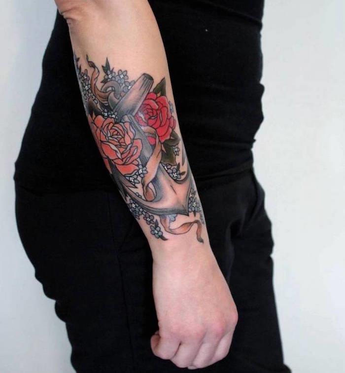 tattoo rose in sidro na podlakti ženske v rdeči oranžni črni barvi in ​​modrih češnjevih cvetovih