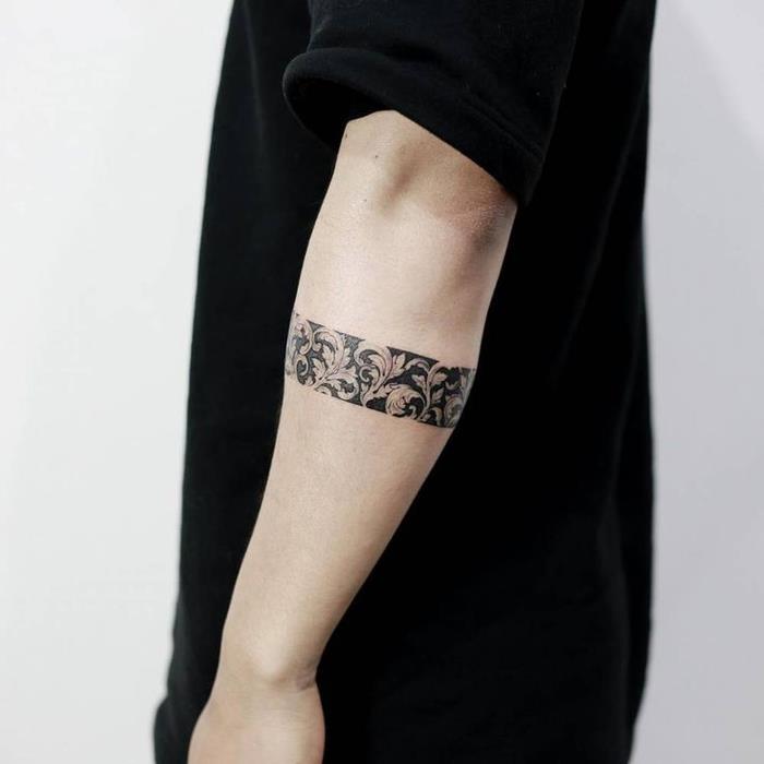 apyrankės tatuiruotė ant rankos, juoda juosta su senoviniais gėlių raštais, vyro tatuiruotės idėja
